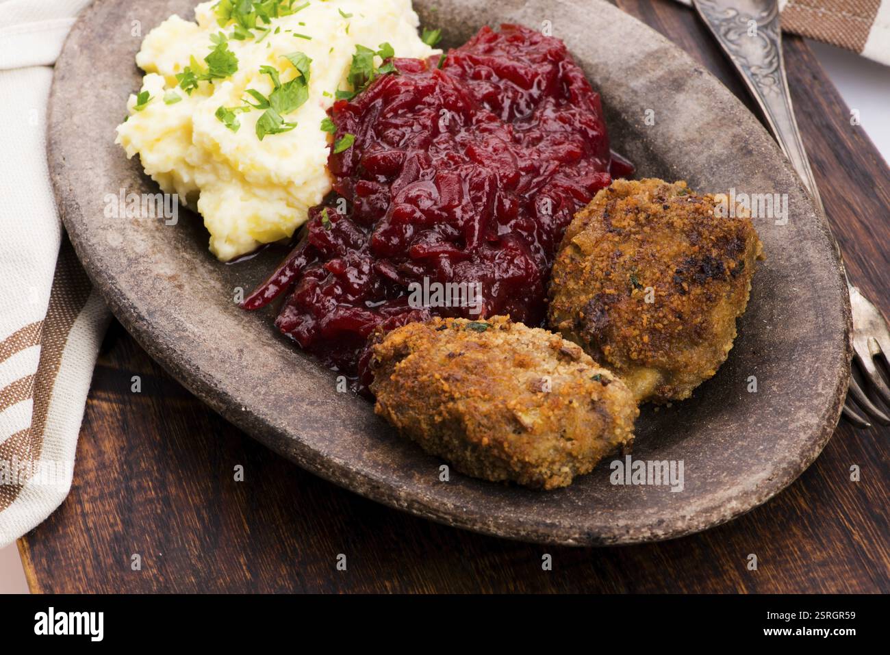 Prepared dinner on the plate. Melted meat, potatoes, beetroot Stock Photo