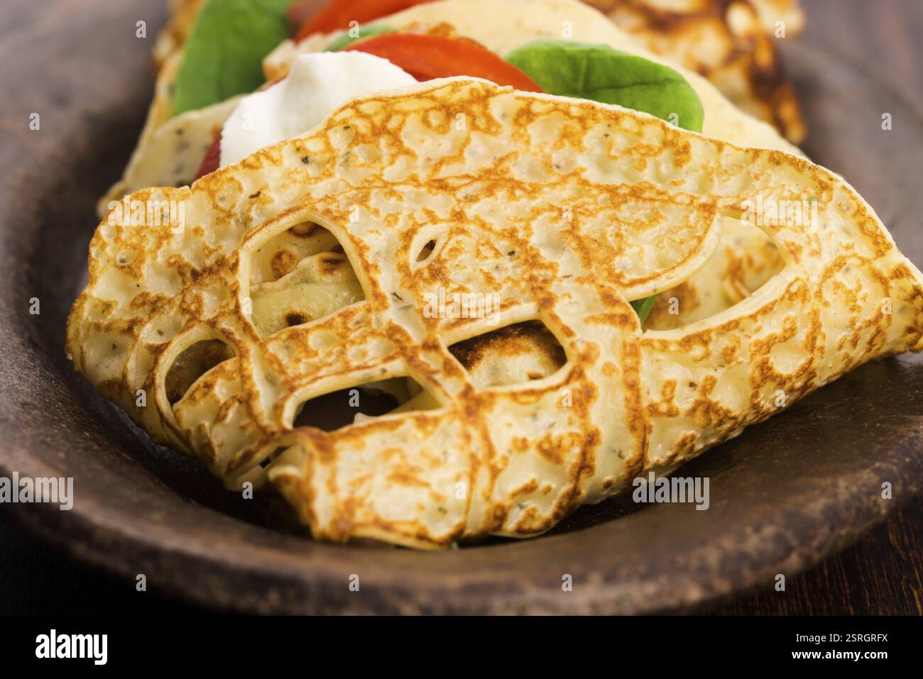 Pancakes sutffed with ham, cheese, tomatoes and spinach Stock Photo