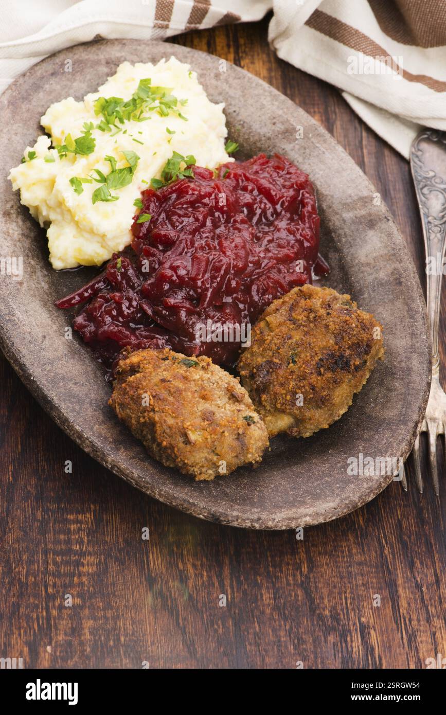 Prepared dinner on the plate. Melted meat, potatoes, beetroot Stock Photo