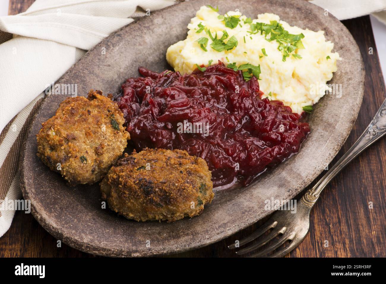 Prepared dinner on the plate. Melted meat, potatoes, beetroot Stock Photo