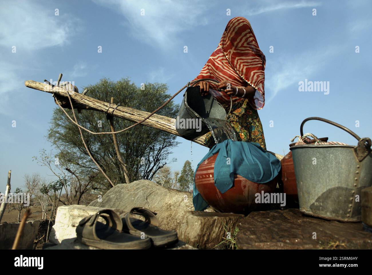 Fetching Lady Rajasthani lady fetch drinking water from well pouring in pot ...