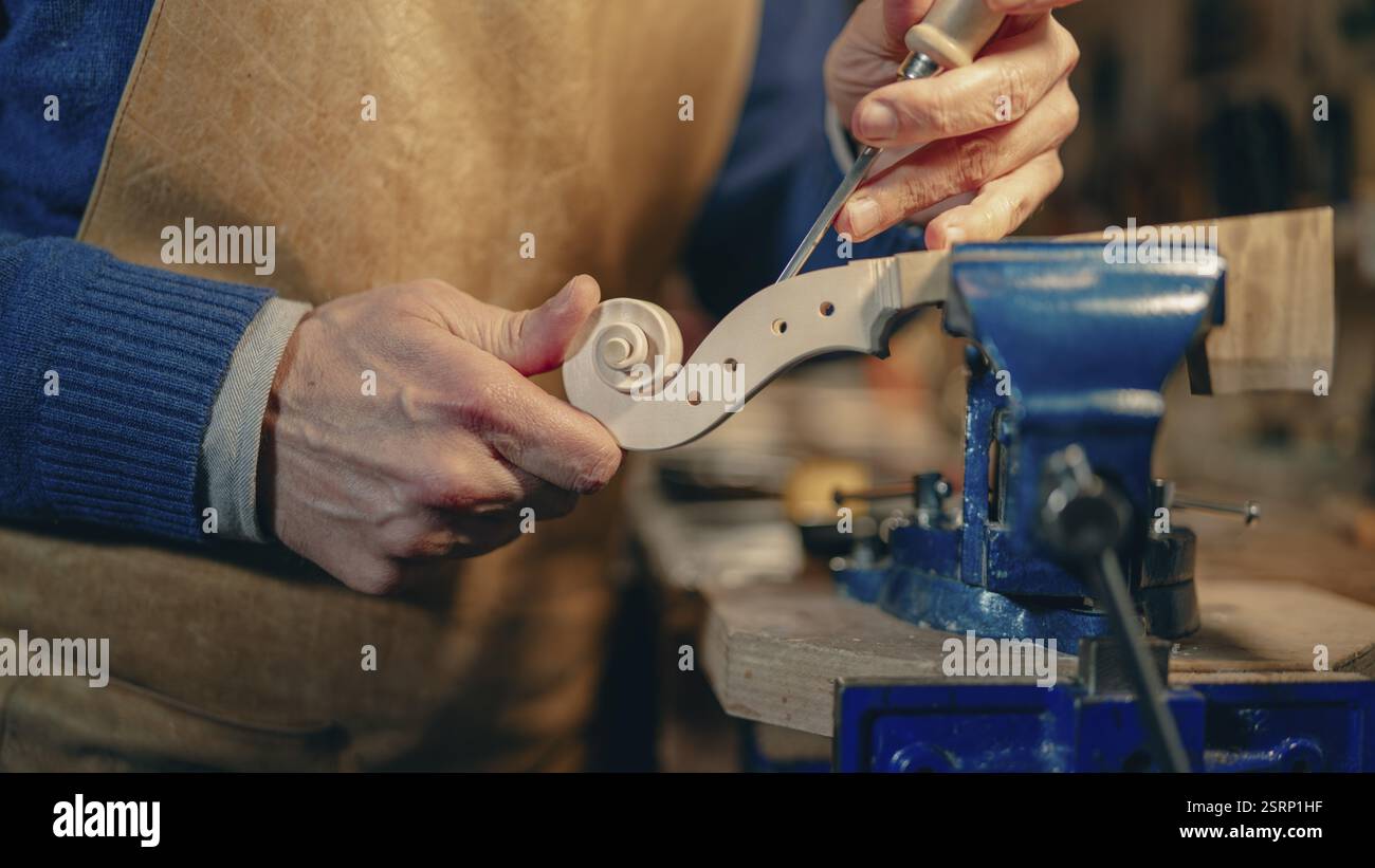 Skilled luthier crafting a violin scroll with precision and specialized ...