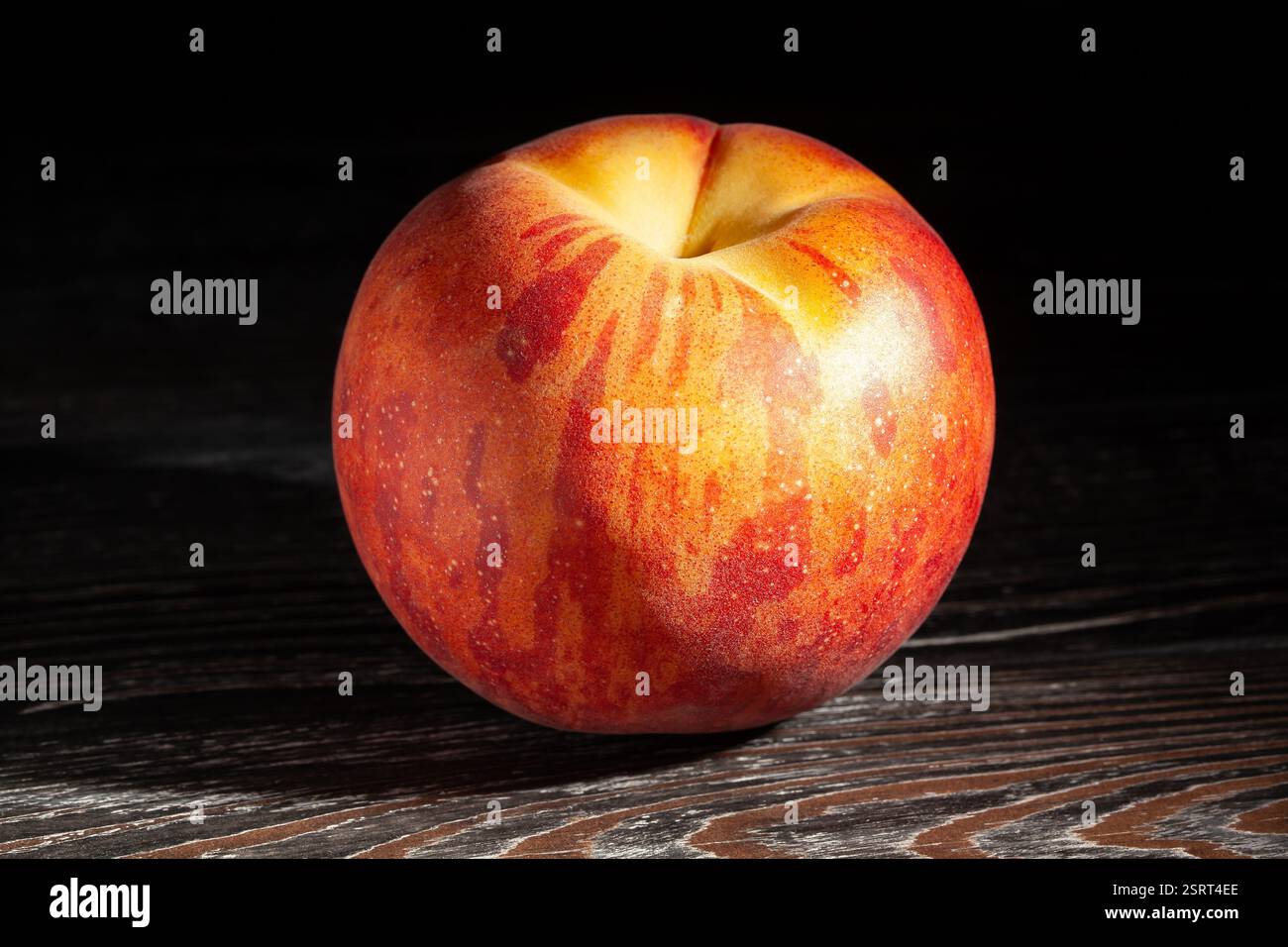 peach on black wood background Stock Photo