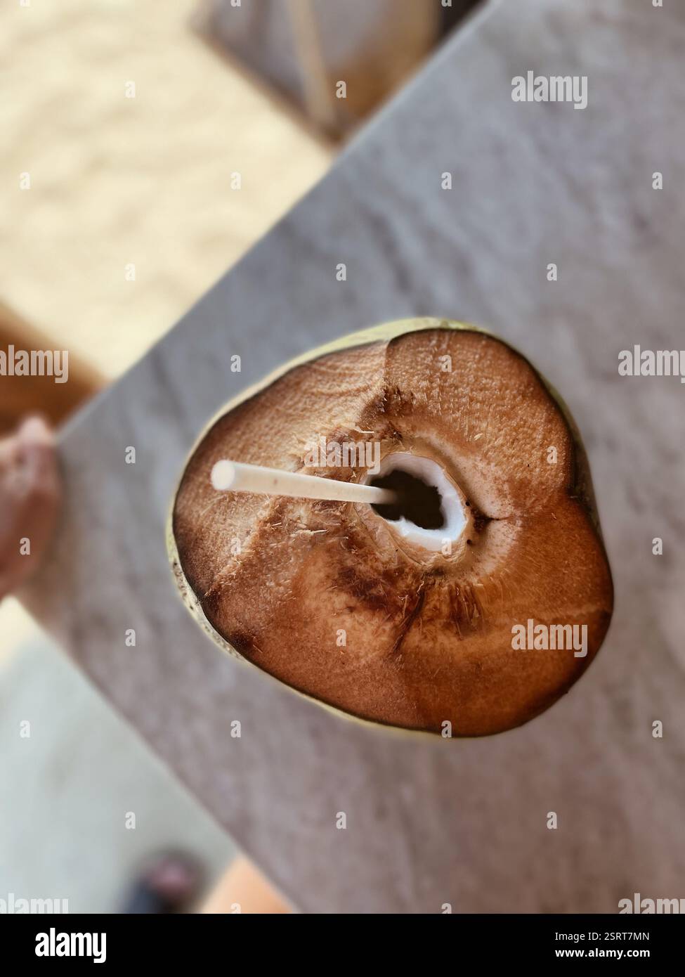 Coconut with a straw from above - Smartphone Captured Stock Image