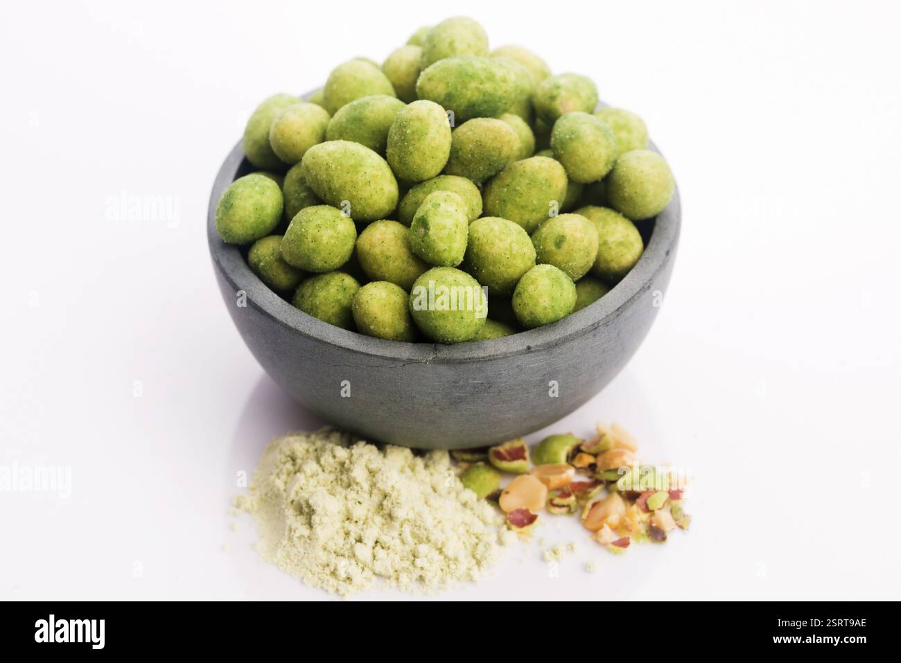 Pile of wasabi coated peanuts in bowl Stock Photo