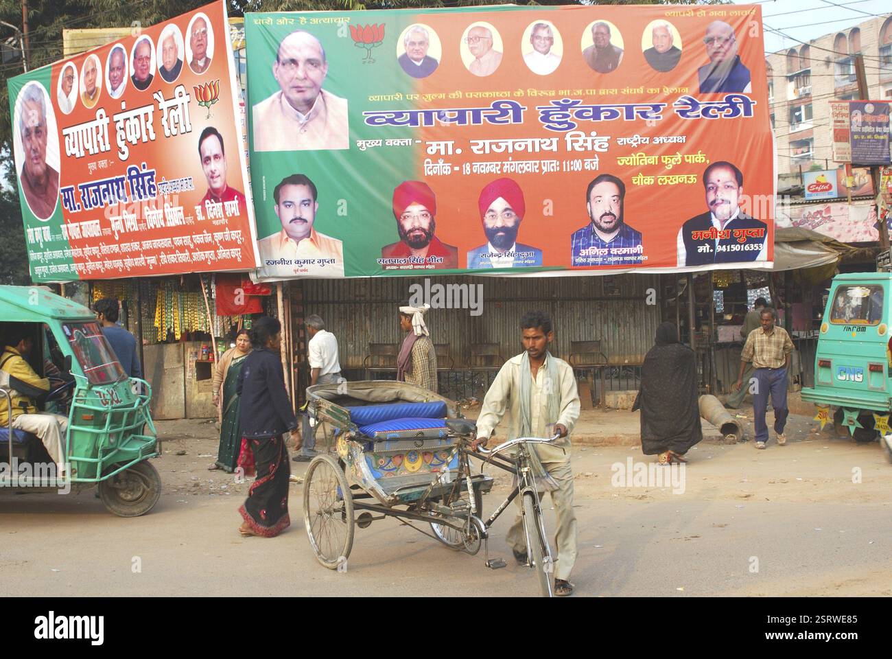 Rickshaw rider and big hoardings of political leaders in backdrop ...