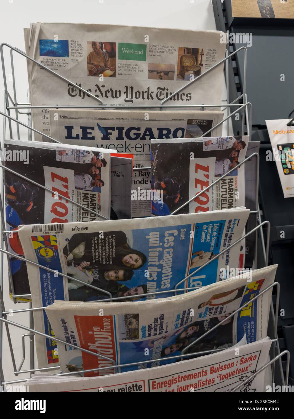 Exploring global headlines in a bustling city newsstand during the morning rush Stock Photo