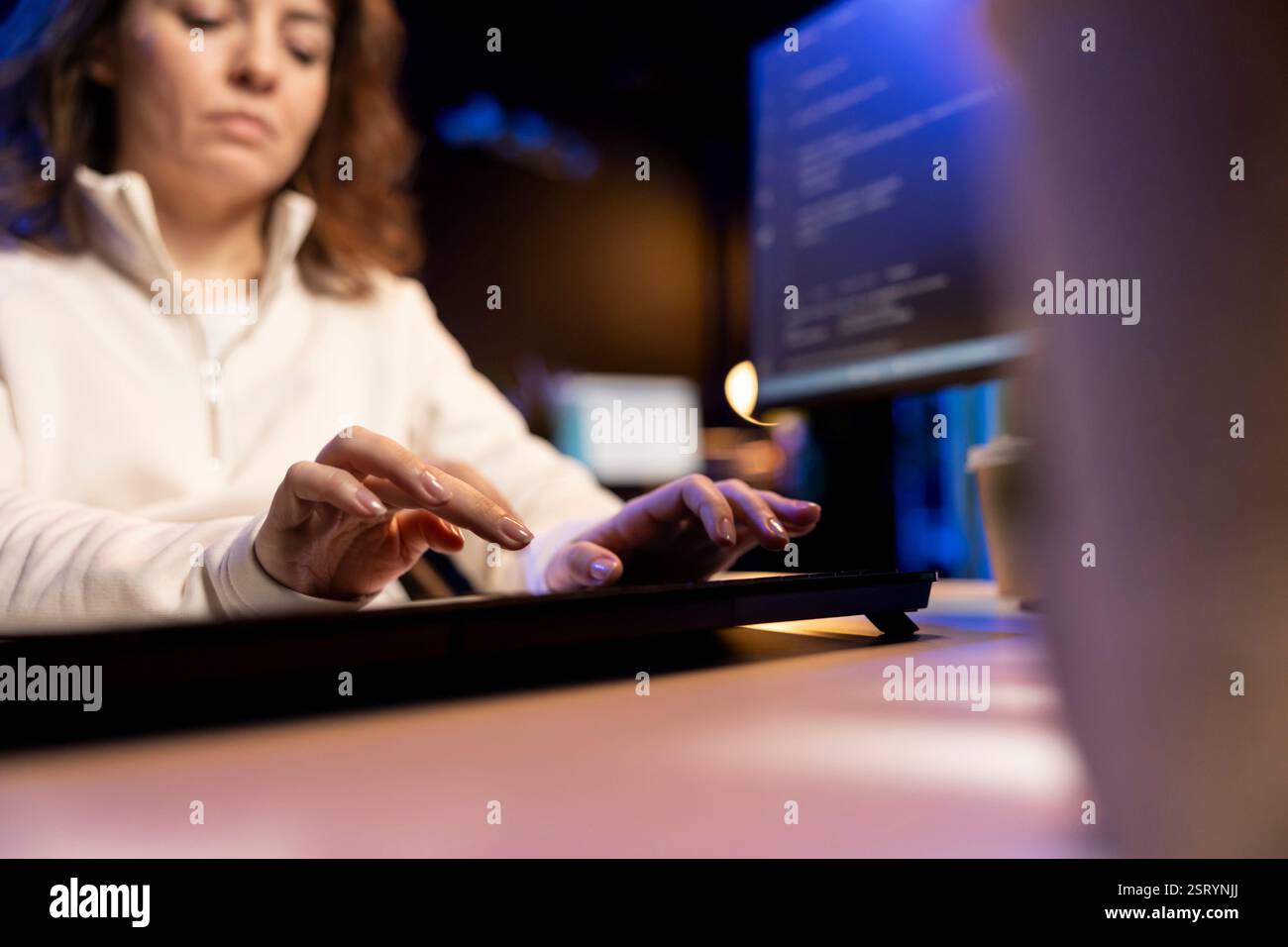 Teleworking programmer doing software debugging, checking flaws in lines of code displayed on PC monitors. IT admin in apartment fixing coding issues, typing on PC keyboard Stock Photo