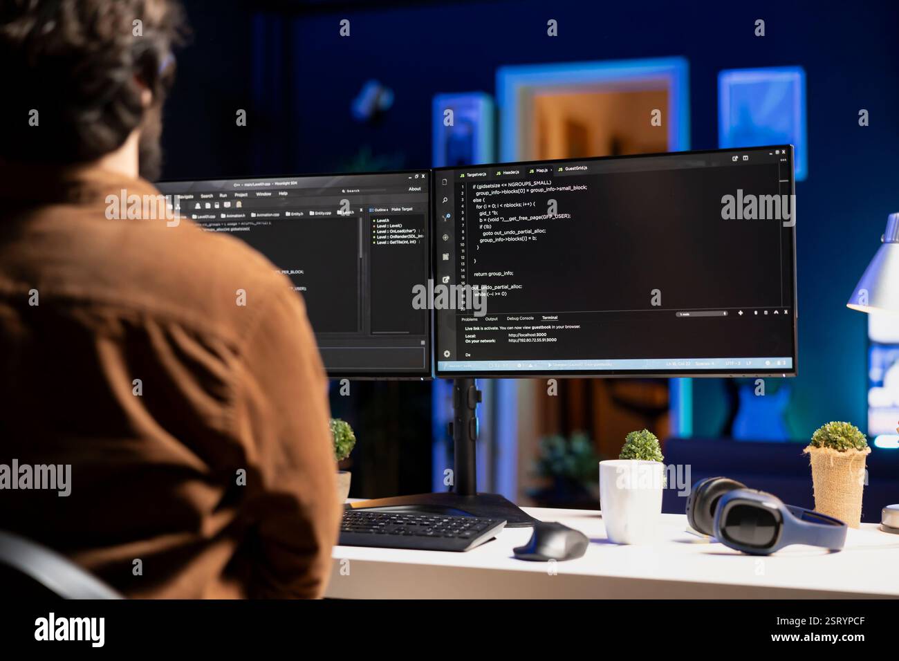 Man working from home implementing security measures to protect company systems and data. Tech support IT worker writing, testing and debugging code for software applications Stock Photo