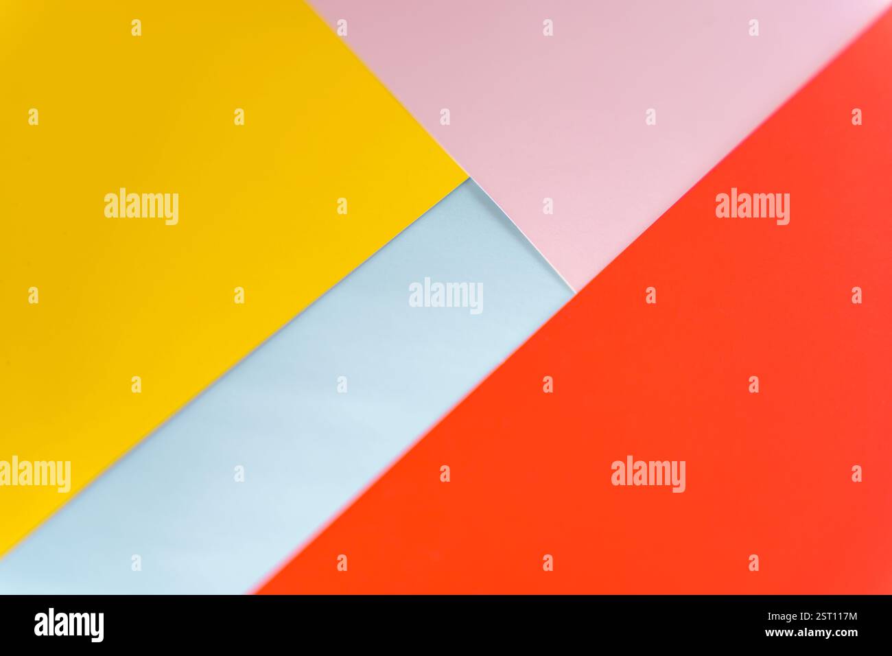 Modern abstract background featuring overlapping yellow, red, pink, and blue paper layers. Vibrant geometric composition ideal for design, branding, o Stock Photo