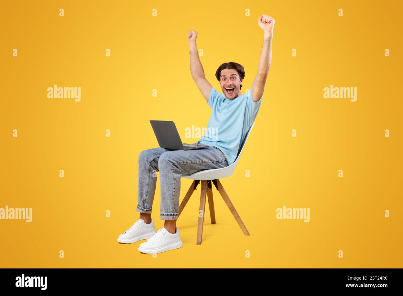 Excited guy using laptop celebrating success shaking fists Stock Photo