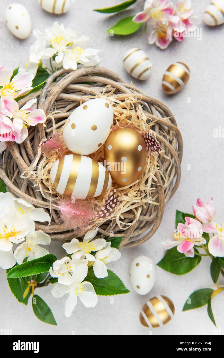 Easter eggs with gold and white decorations lying in a nest with spring ...