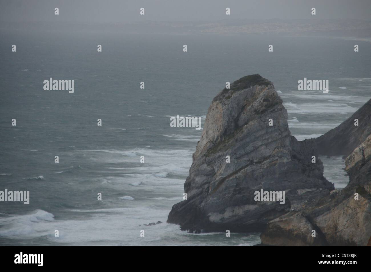 Rugged cliffs defy the relentless ocean. Portugal's western frontier. Europe's westernmost point. Untamed beauty, a testament to nature's power. Stock Photo