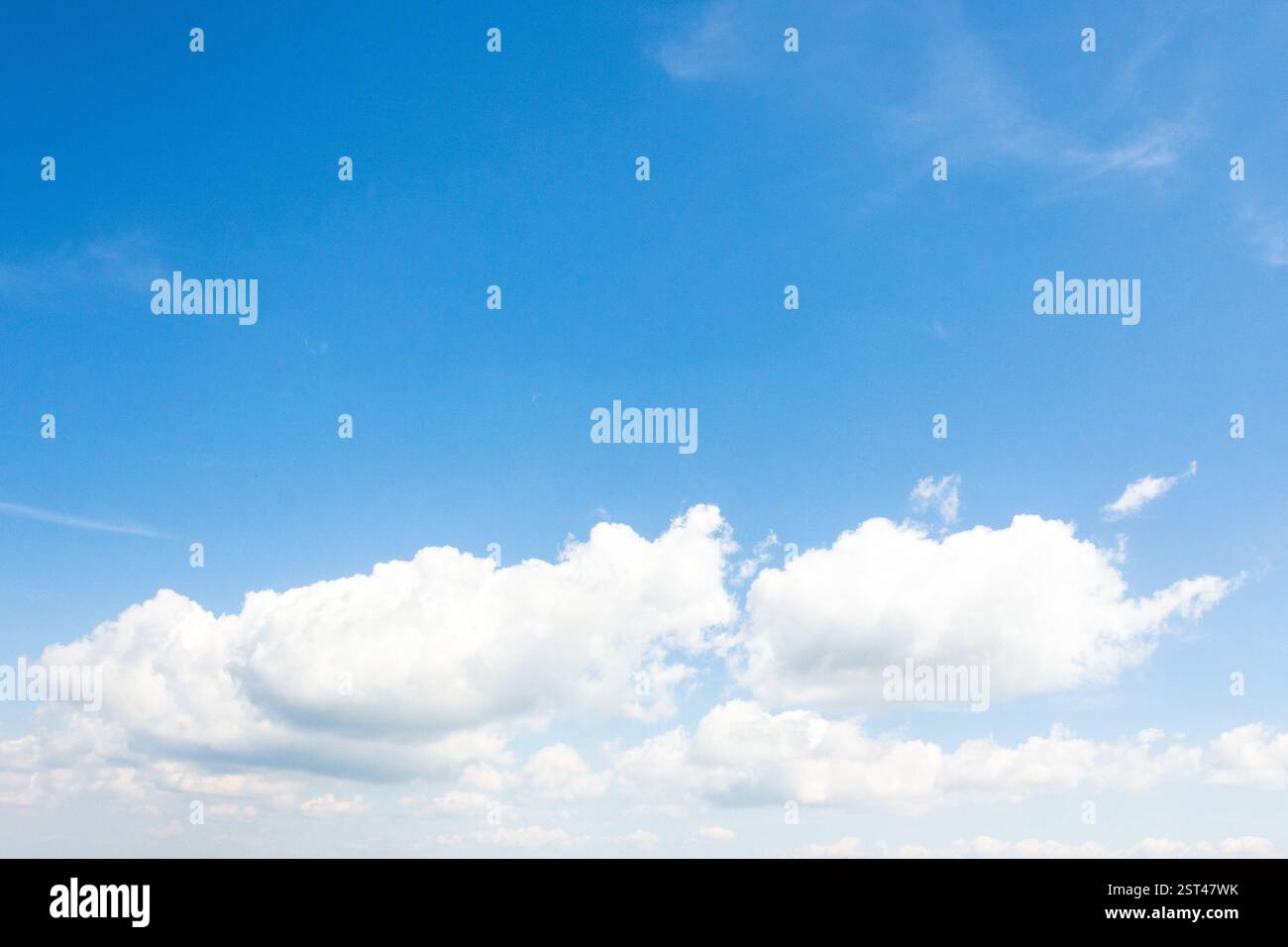 sky with fluffy clouds. dynamic scene in day light. white cumulus cloudscape on a blue gradient of atmosphere. sunny summer weather. scenic nature bac Stock Photo