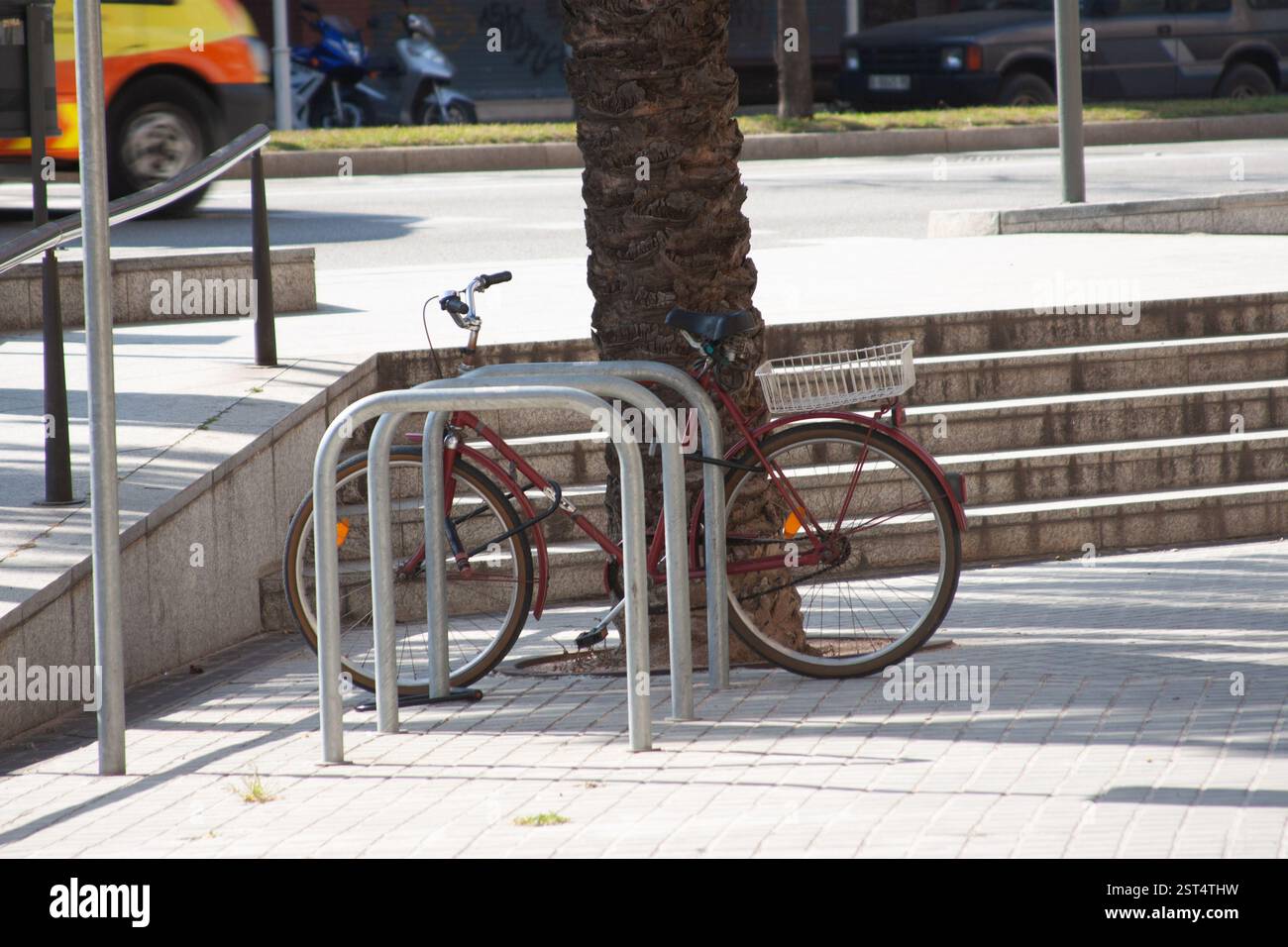 Red bicycle parked at a rack in a sunny urban setting. City life ...