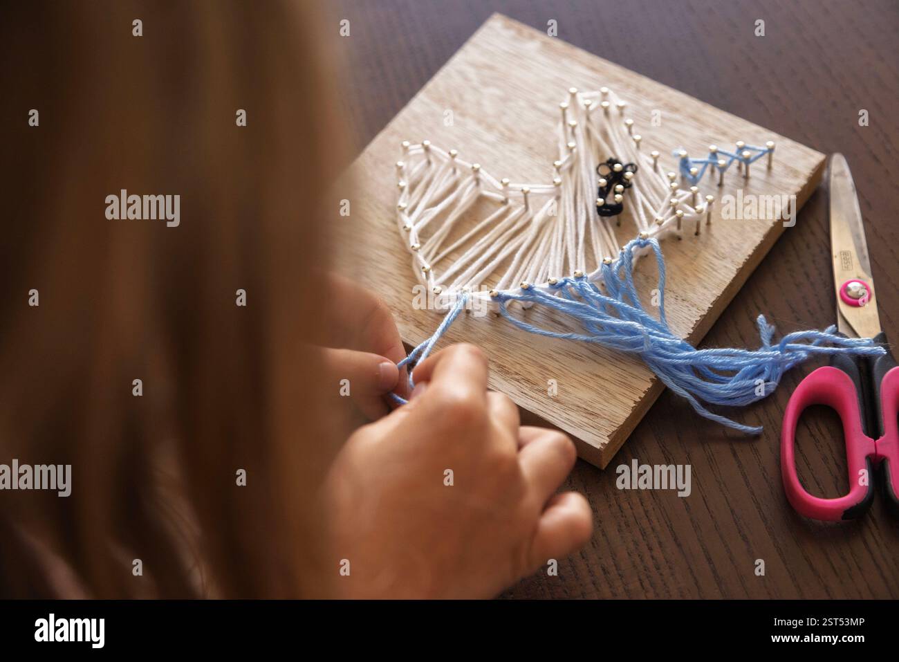 Close-up of a child hands creating string art. Enhancing concentration ...