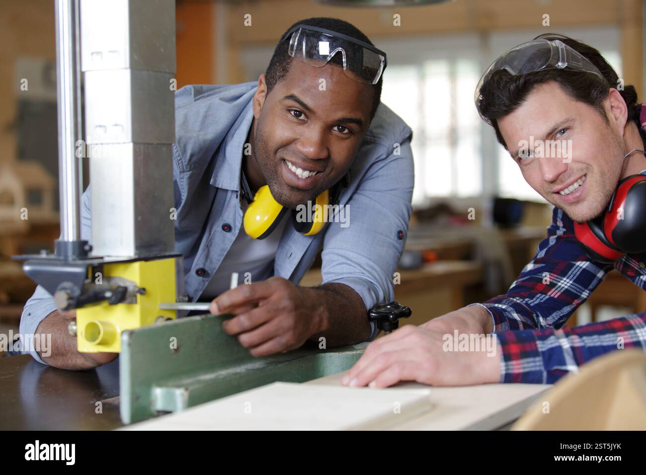 carpenter teaches his apprentice how to use saw machine Stock Photo - Alamy