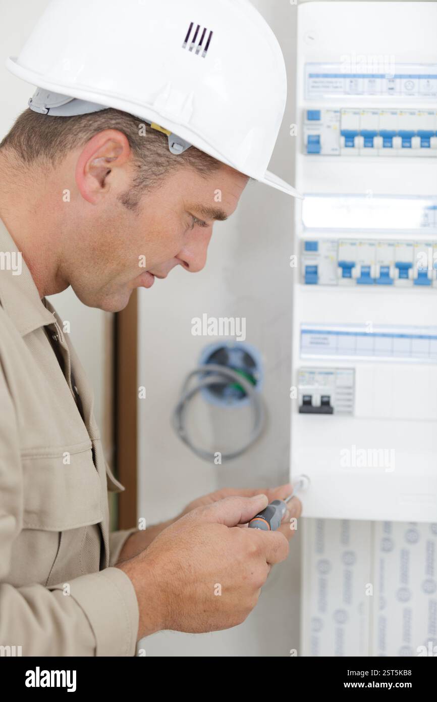 electrician installing energy saving meter Stock Photo