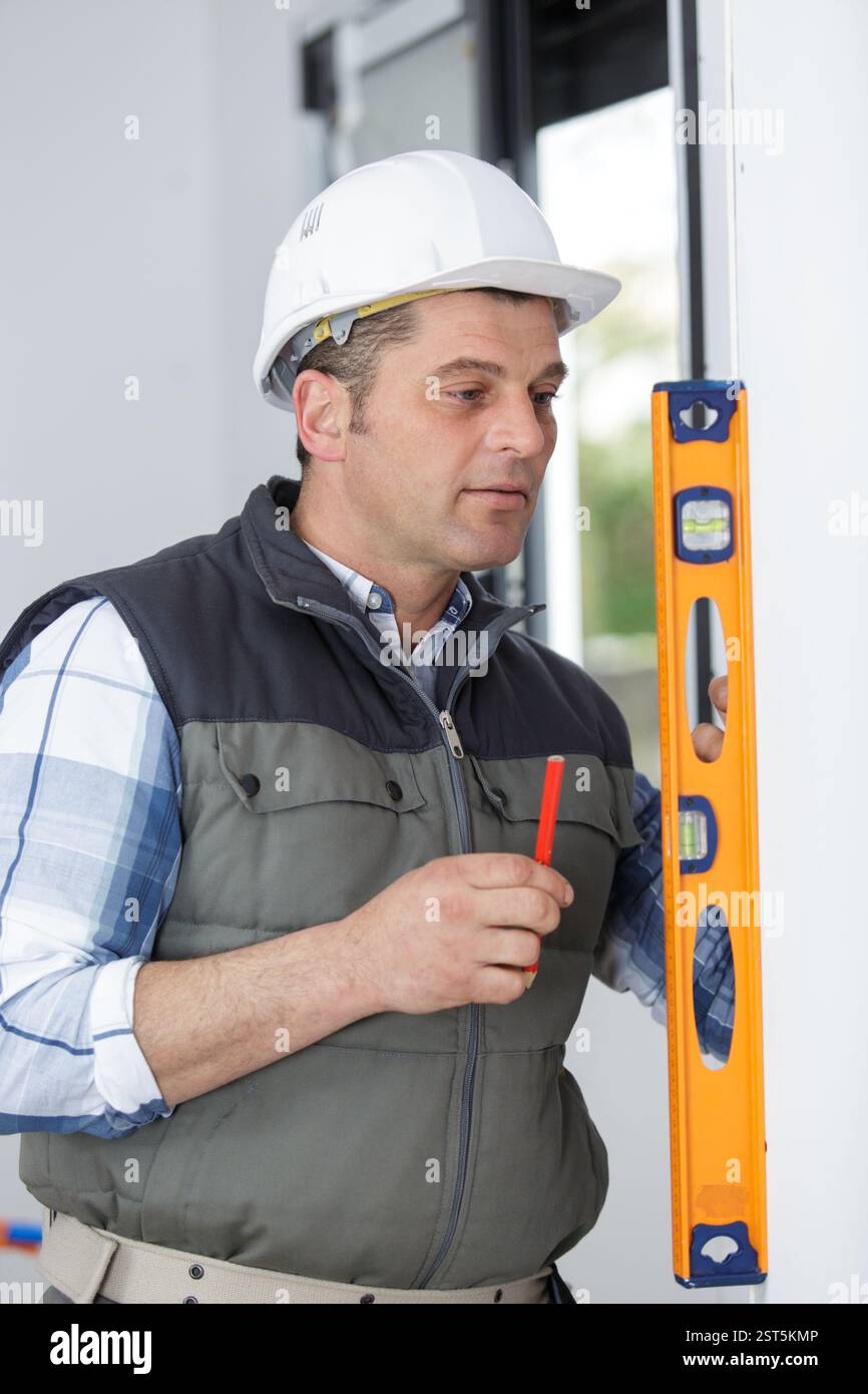 mature builder using spirit level Stock Photo