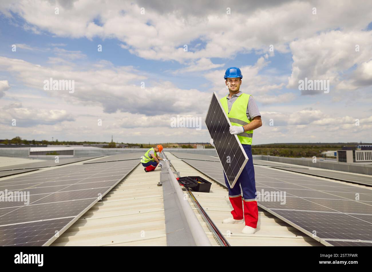Positive Man Worker Installing Solar Panels On Roof Stock Photo