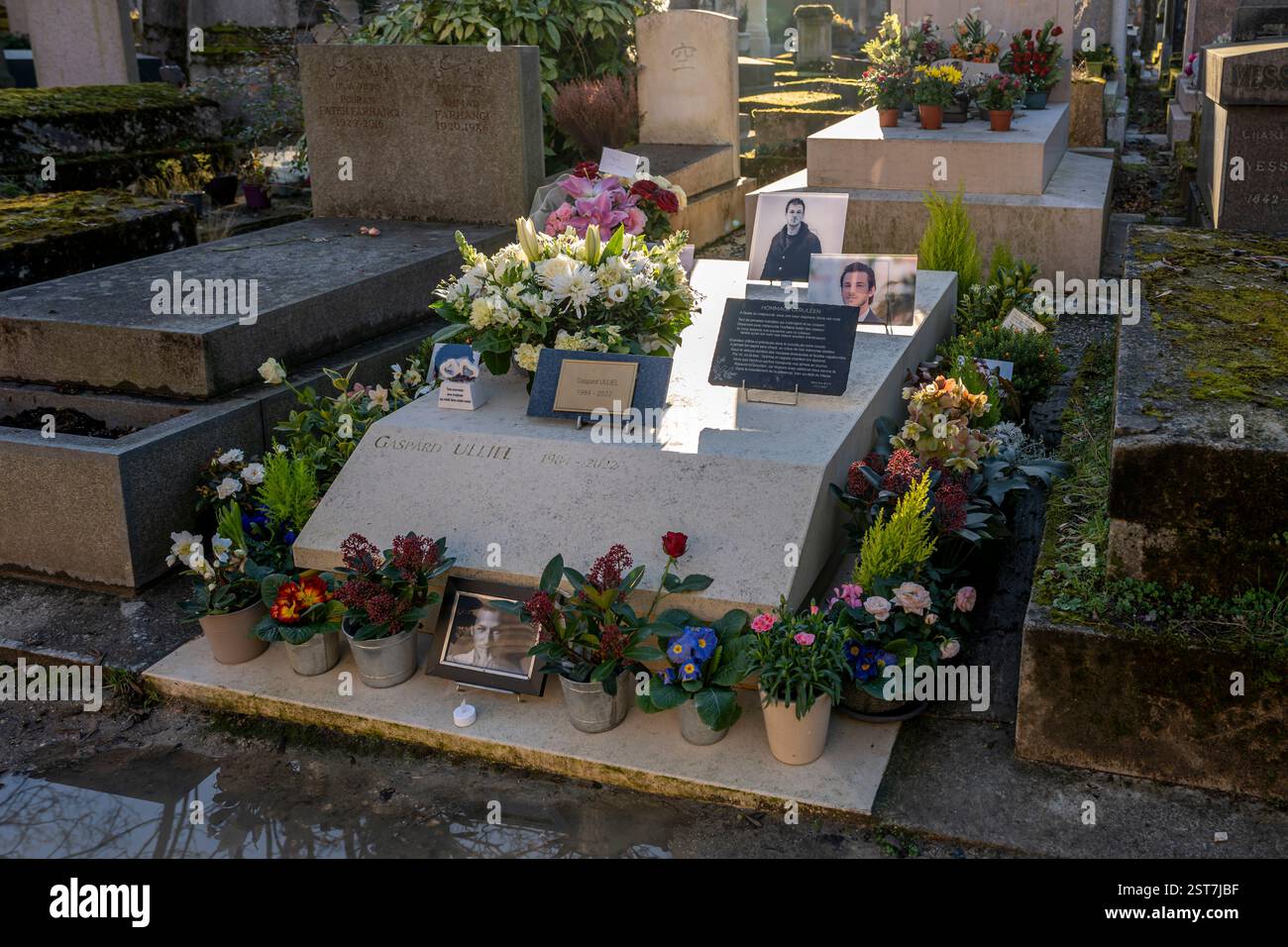 Paris, France - 02 02 2025: Père-Lachaise Cemetery. Gaspard Ulliel's grave covered with flowers, plants and pictures of him Stock Photo