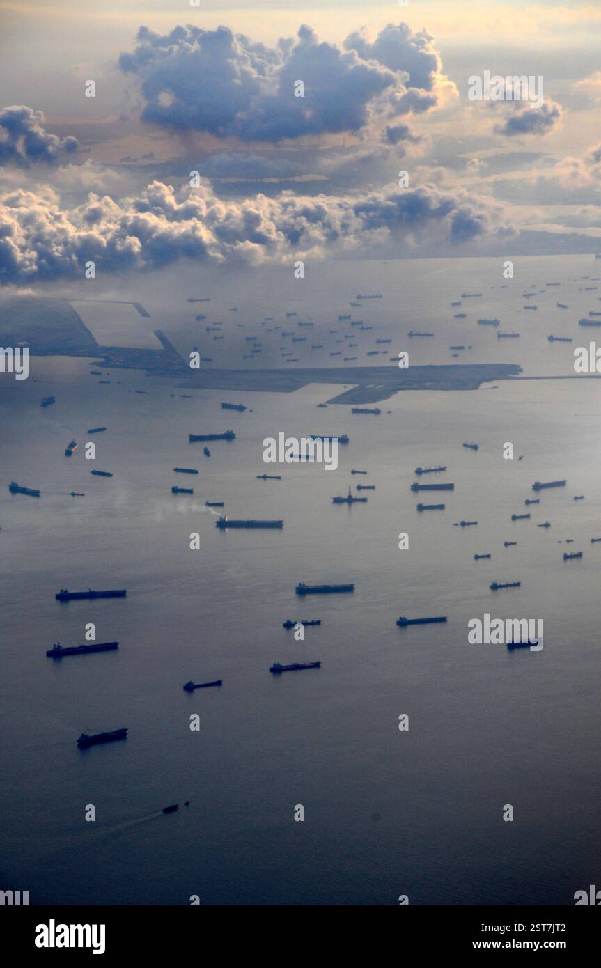 A fleet of anchored cargo/ container ships in the Singapore Strait off the coast of city of Singapore. The 'Singapore Strait harbour' refers to the Po Stock Photo
