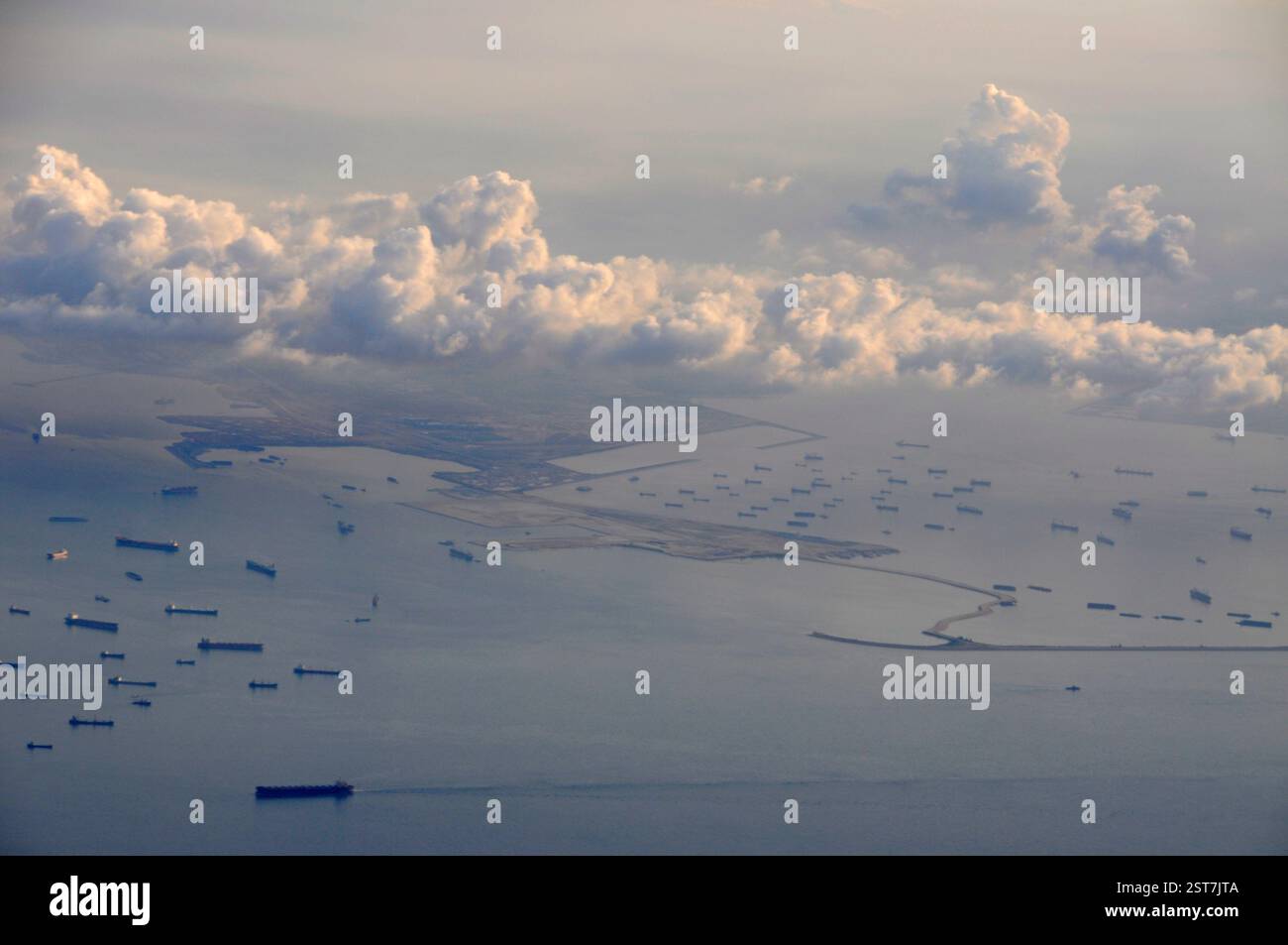 One of the larger islands in the in the Singapore Strait, facing Singapore with a fleet of anchored cargo/ container ships off its coast. Stock Photo