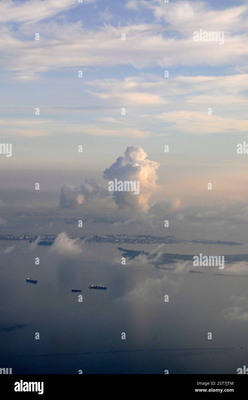 One of the larger islands in the in the Singapore Strait, facing Singapore with a fleet of anchored cargo/ container ships off its coast. Stock Photo