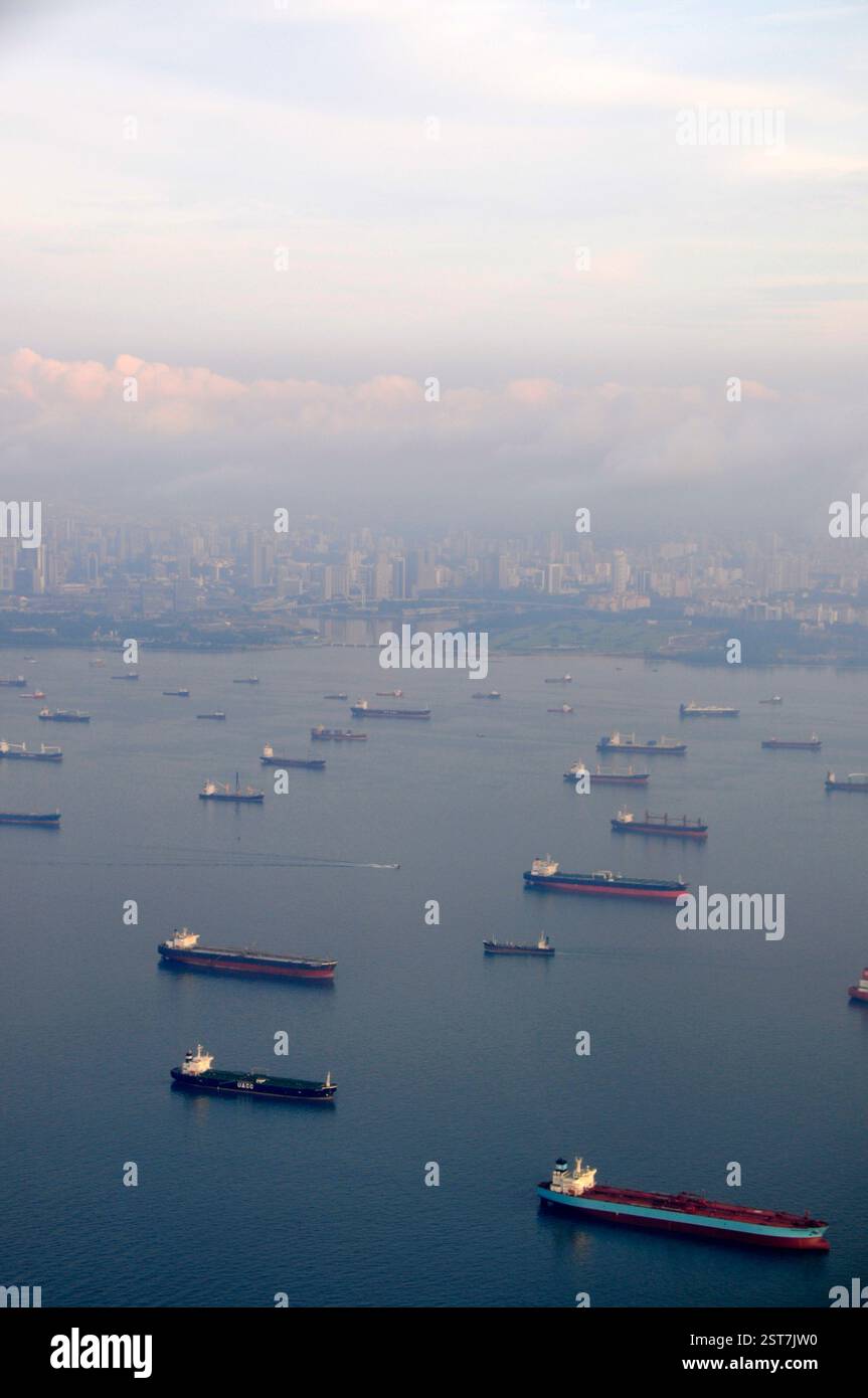 A fleet of anchored cargo/ container ships in the Singapore Strait off the coast of city of Singapore. The 'Singapore Strait harbour' refers to the Po Stock Photo