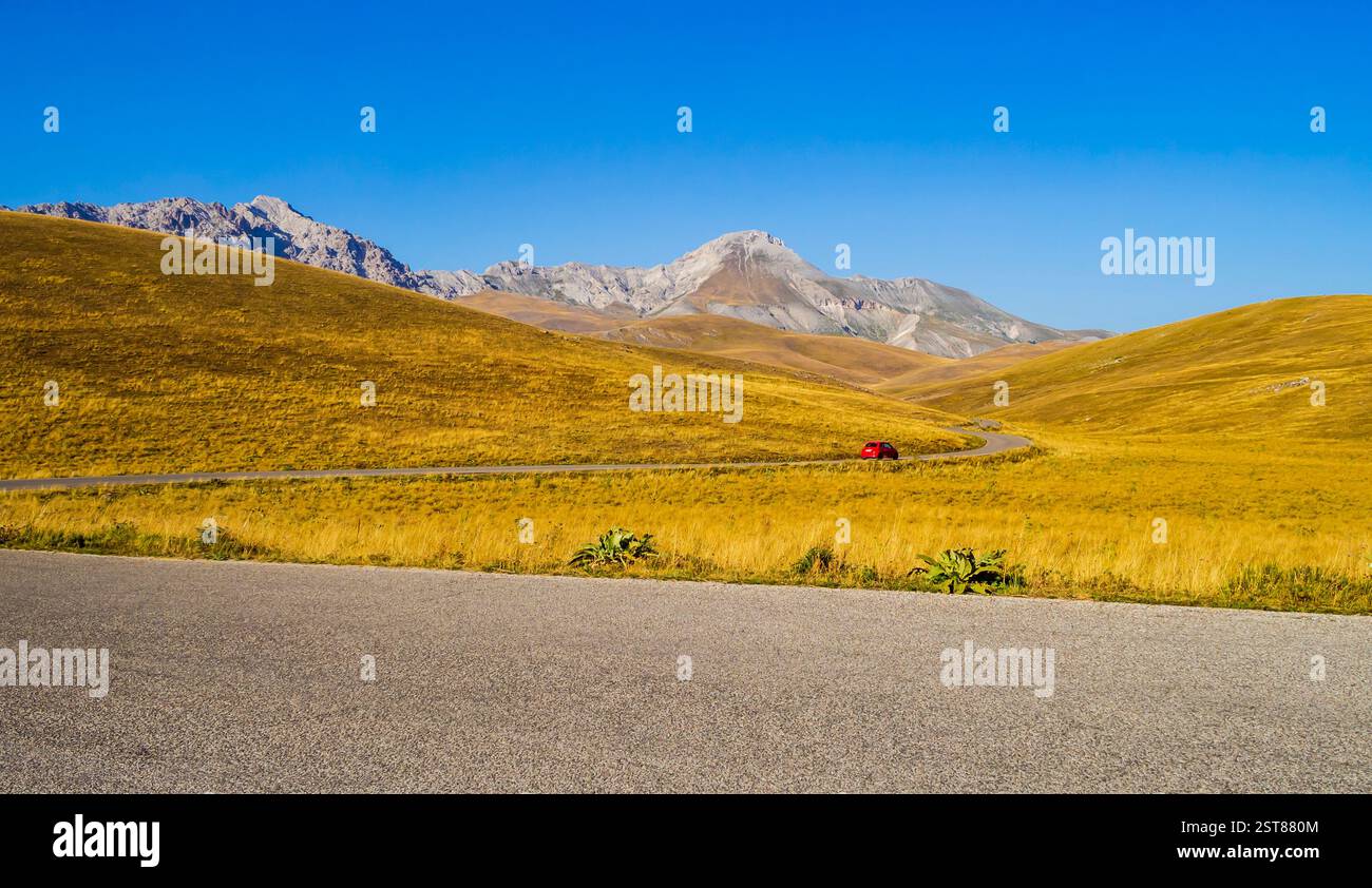 Beautiful red car racing along the winding roads of Campo Imperatore ...
