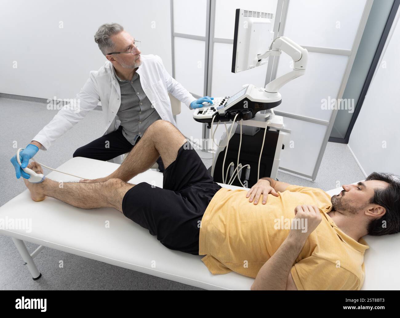 Adult man lying on medical couch receives modern diagnosis of injured ...