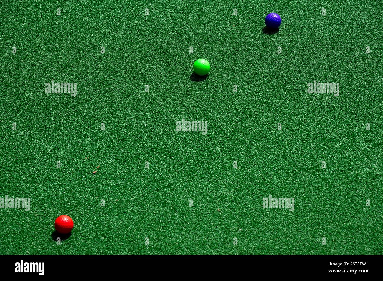 Close view of colorful golf balls on putting green. Stock Photo