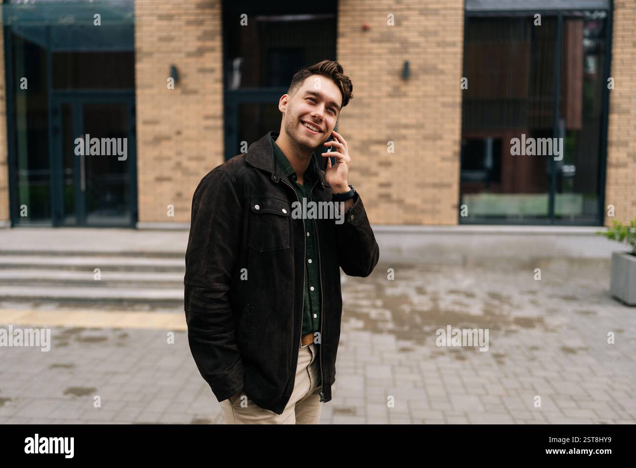 Medium shot portrait of elegant young man making phone call standing ...