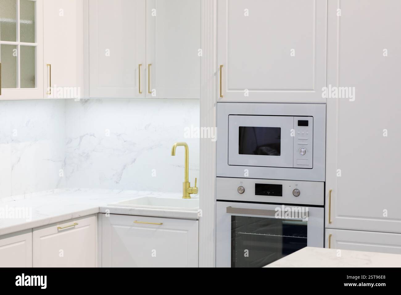 Modern residential kitchen interior with white cabinets. Selective focus. Stock Photo