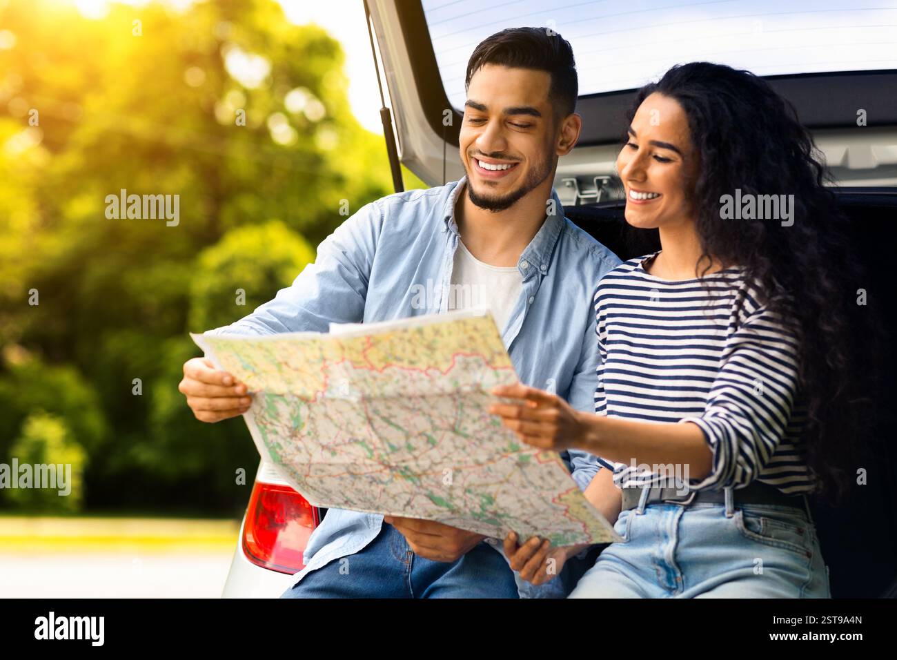 Loving middle-eastern couple watching map while having break Stock Photo