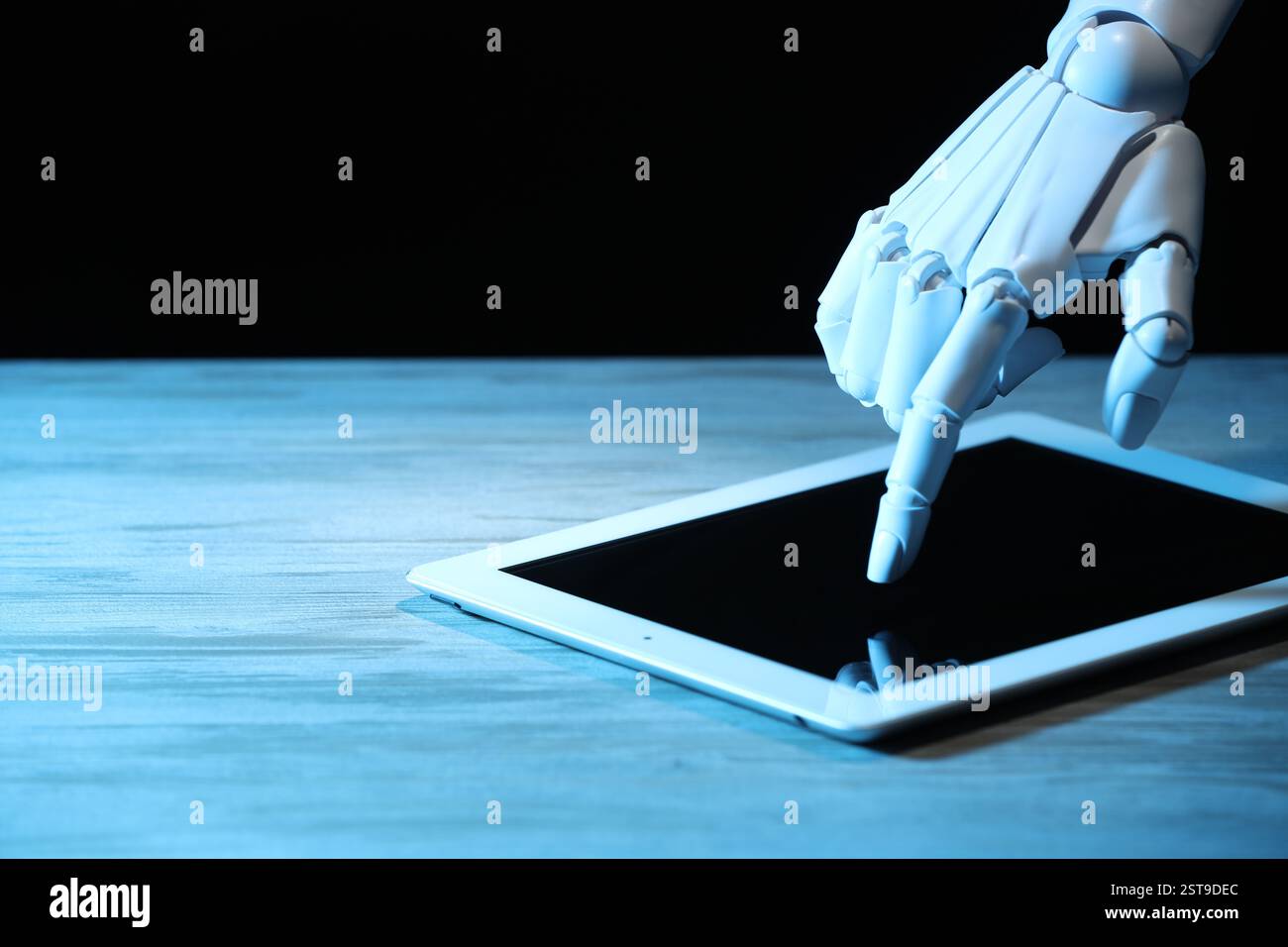 Artificial intelligence. Robot hand using tablet at wooden table, closeup. Space for text Stock Photo
