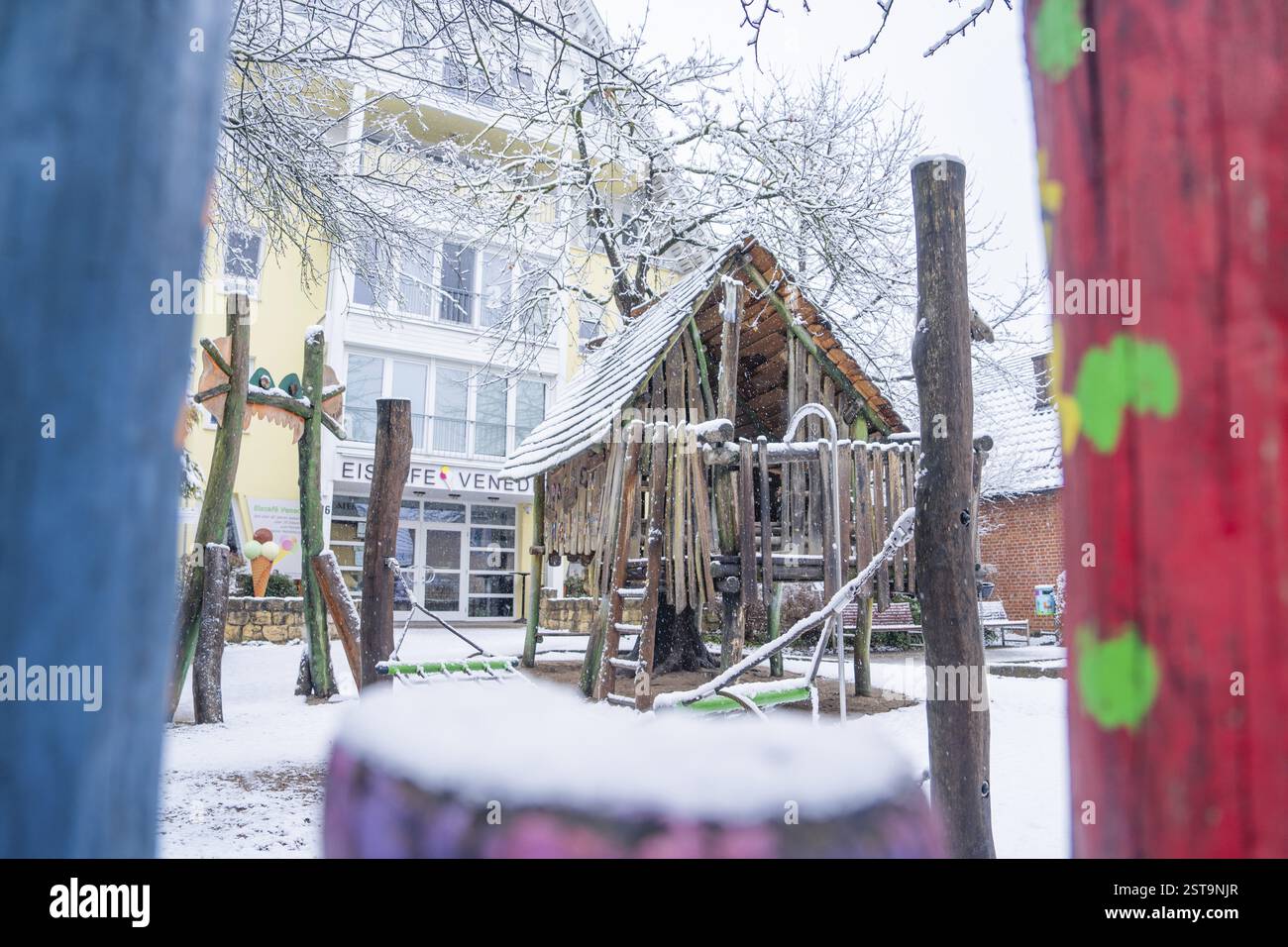 Snow-covered playground in front of an ice cream parlour with wooden elements and colourful painting, Sindelfingen, Germany, Europe Stock Photo