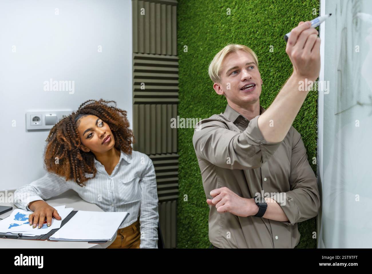 Two managers are discussing and brainstorming, writing ideas on a ...