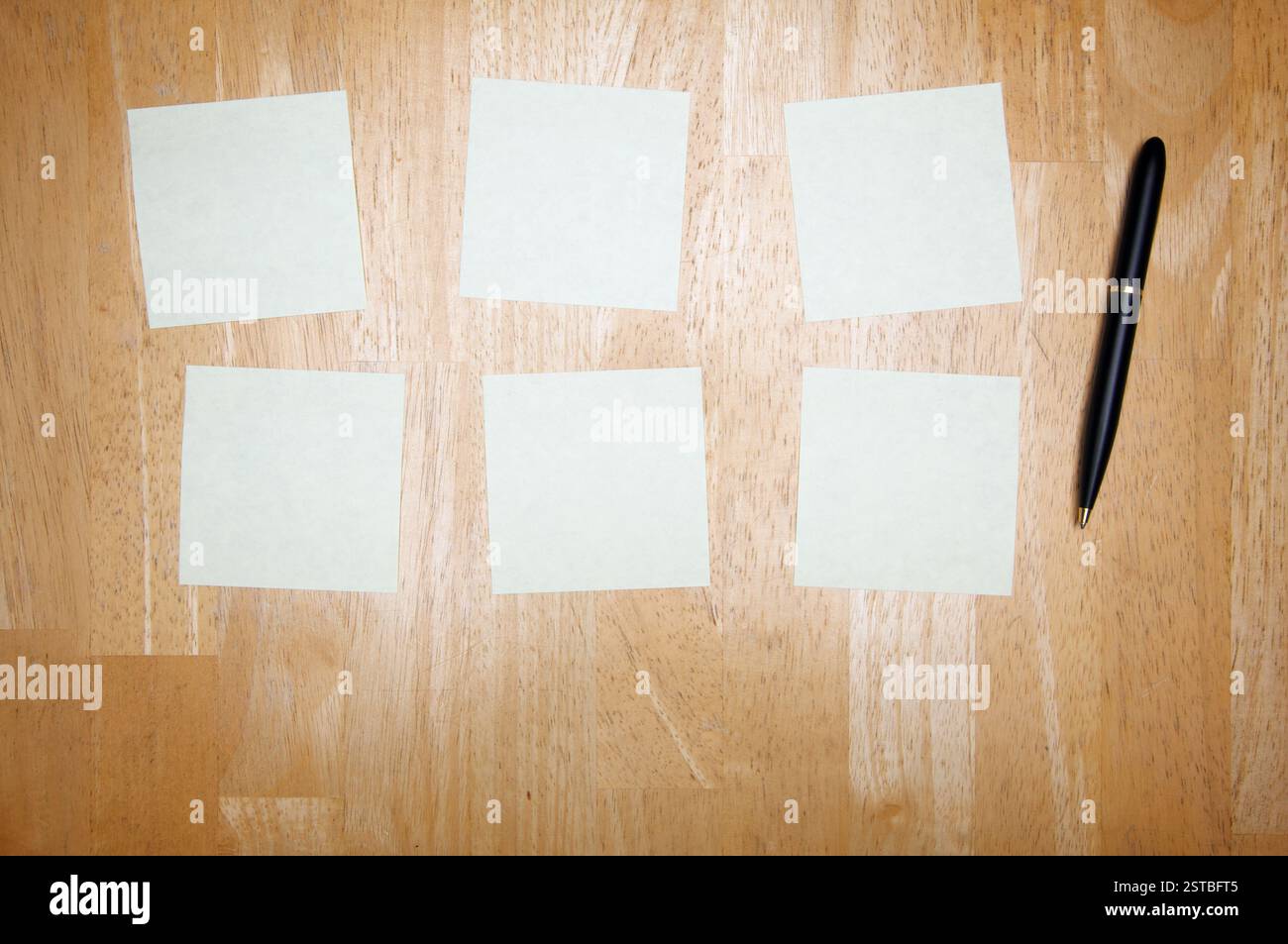 Pen and Post It Notes Pad Against a Wood Background Stock Photo