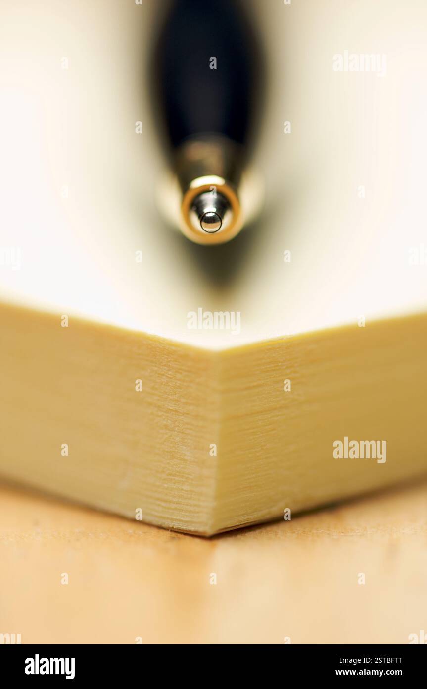 Pen and Post It Notes Pad Against a Wood Background Stock Photo