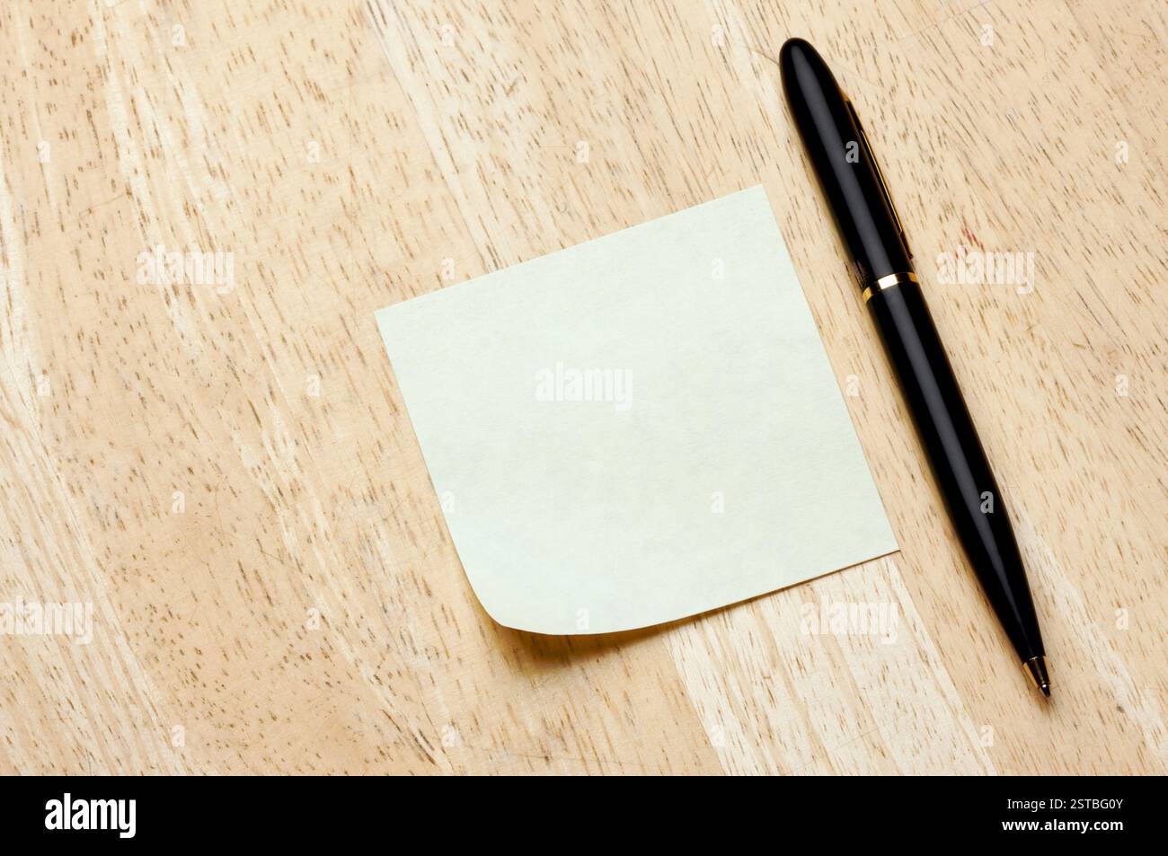 Pen and Post It Notes Pad Against a Wood Background Stock Photo
