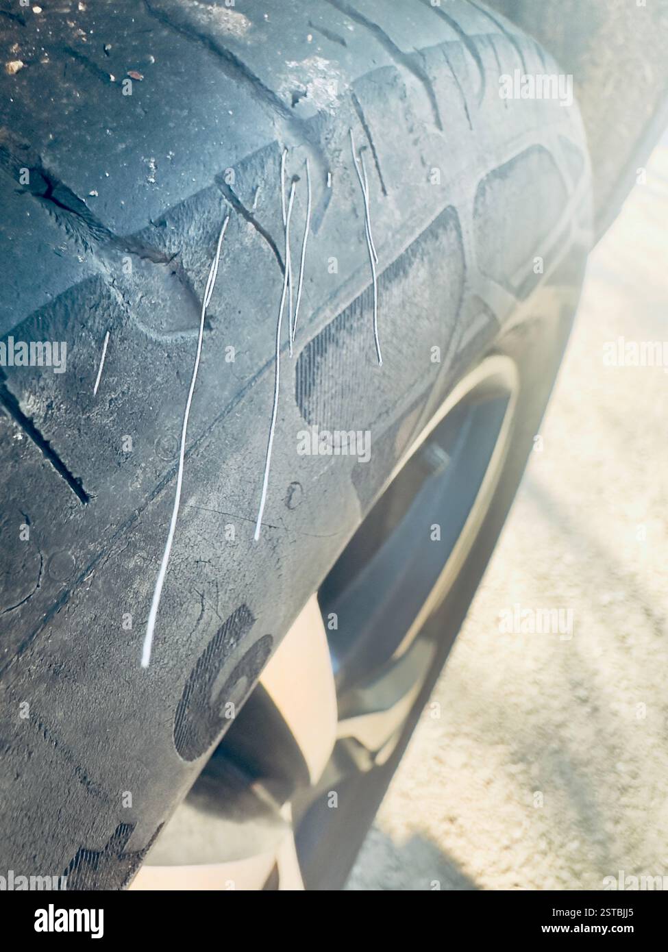 Dangerous and illegal worn car tyre showing internal steel wires protruding Stock Photo