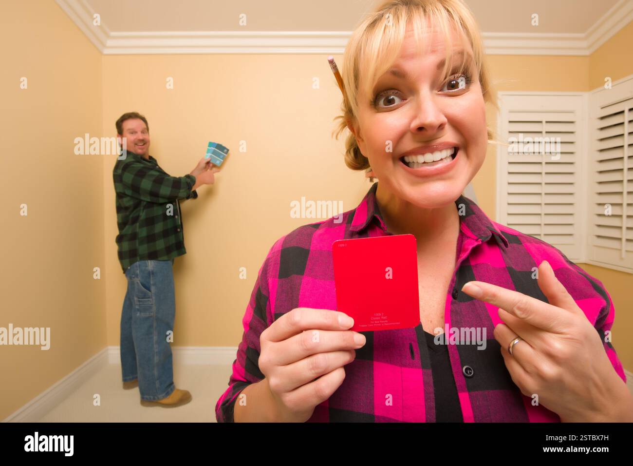 Couple Comparing Paint Colors in Empty Room Stock Photo - Alamy