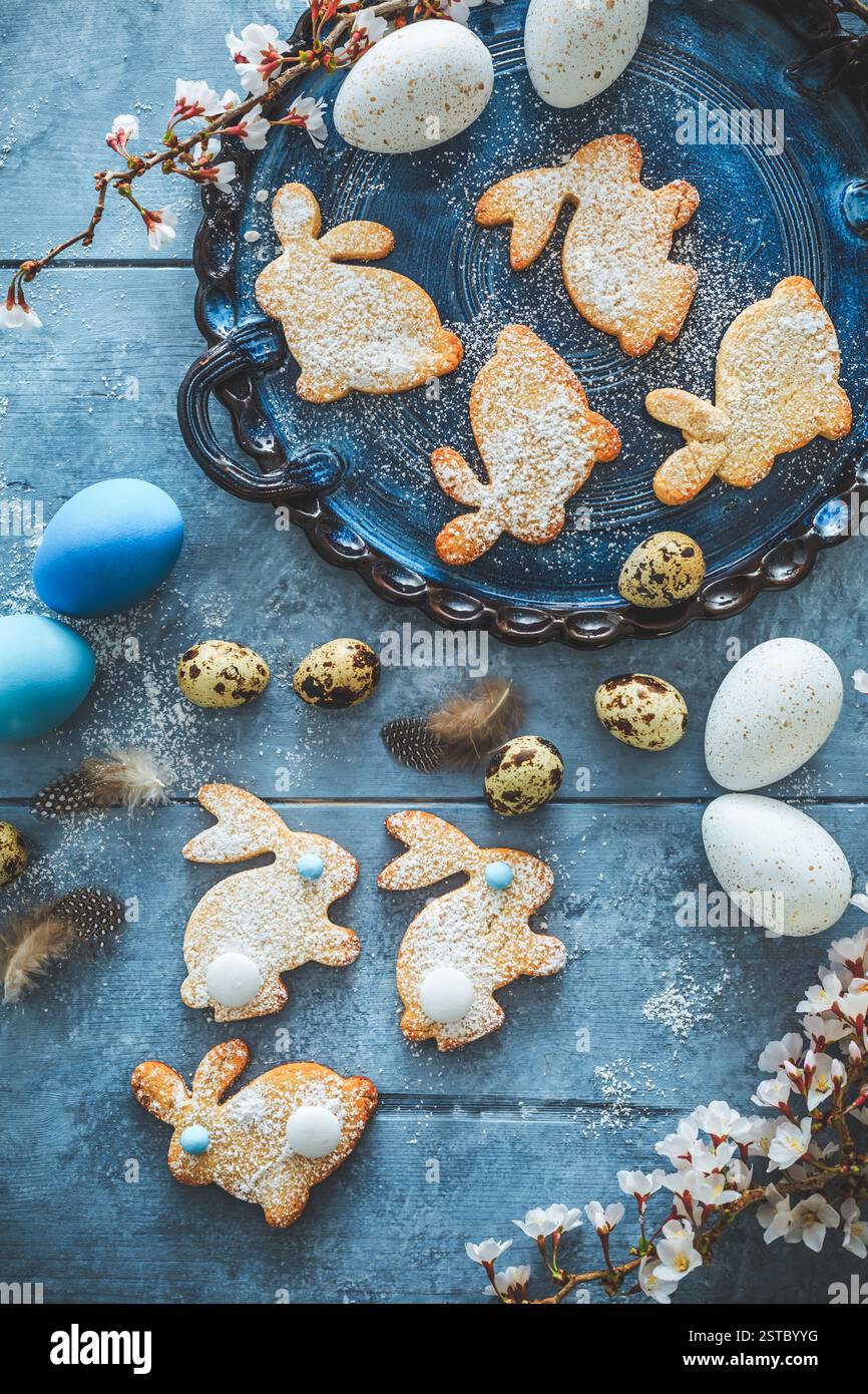 Homemade almond bunny cookies for Easter with Easter eggs in blue tone Stock Photo