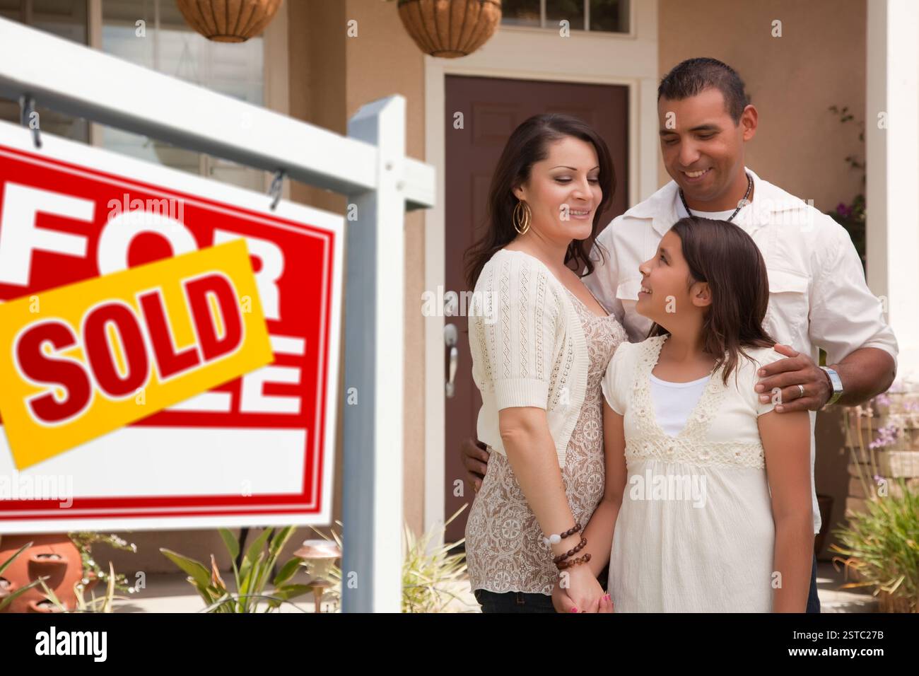 Hispanic Family in Front of Their New Home with Sold Sign Stock Photo ...