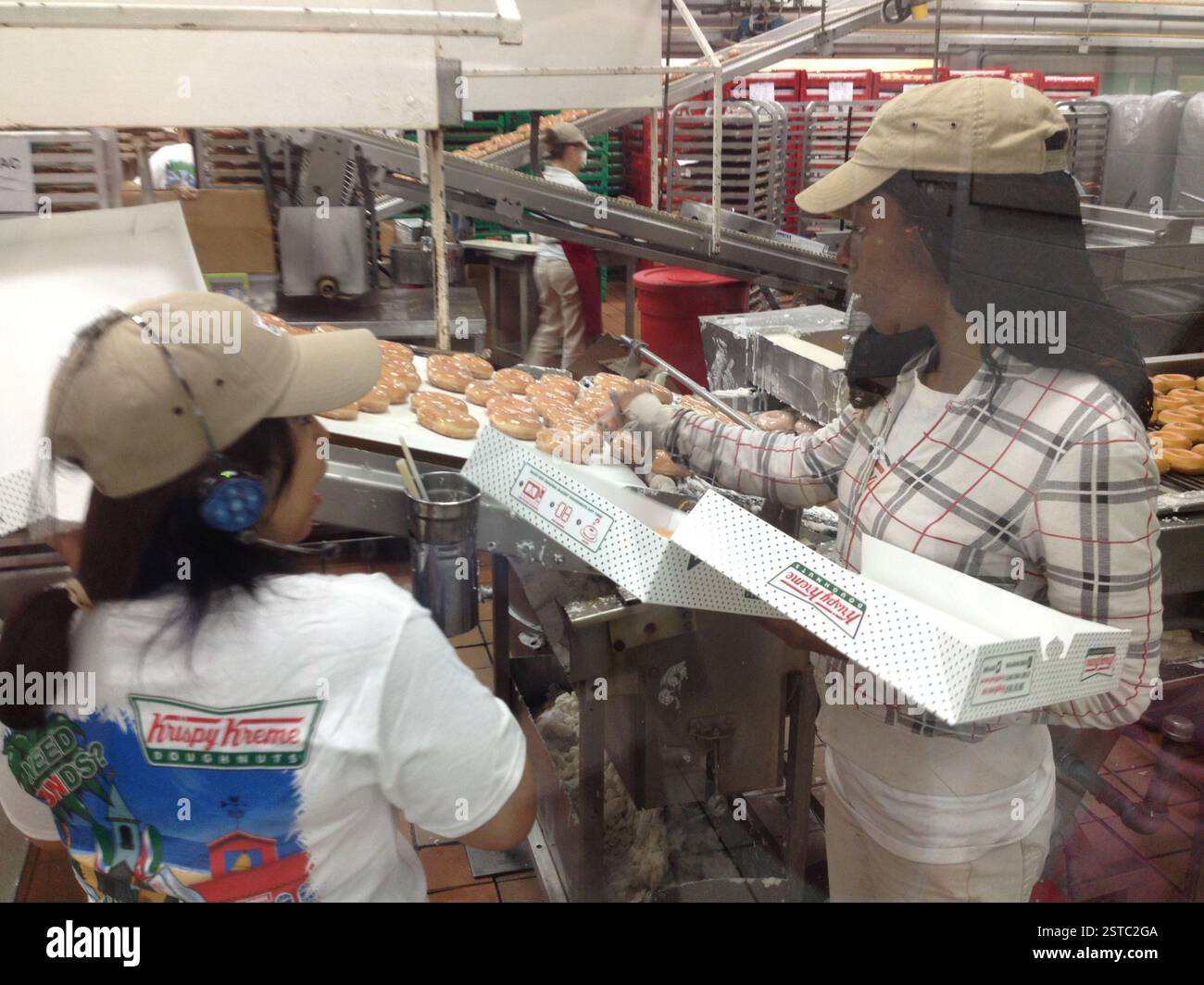 Miami storefront displaying misspelled Krispy Kreme logo. Illuminated red Krispy Kreme sign glows brightly. Humorous misspelling on iconic sweet treat Stock Photo