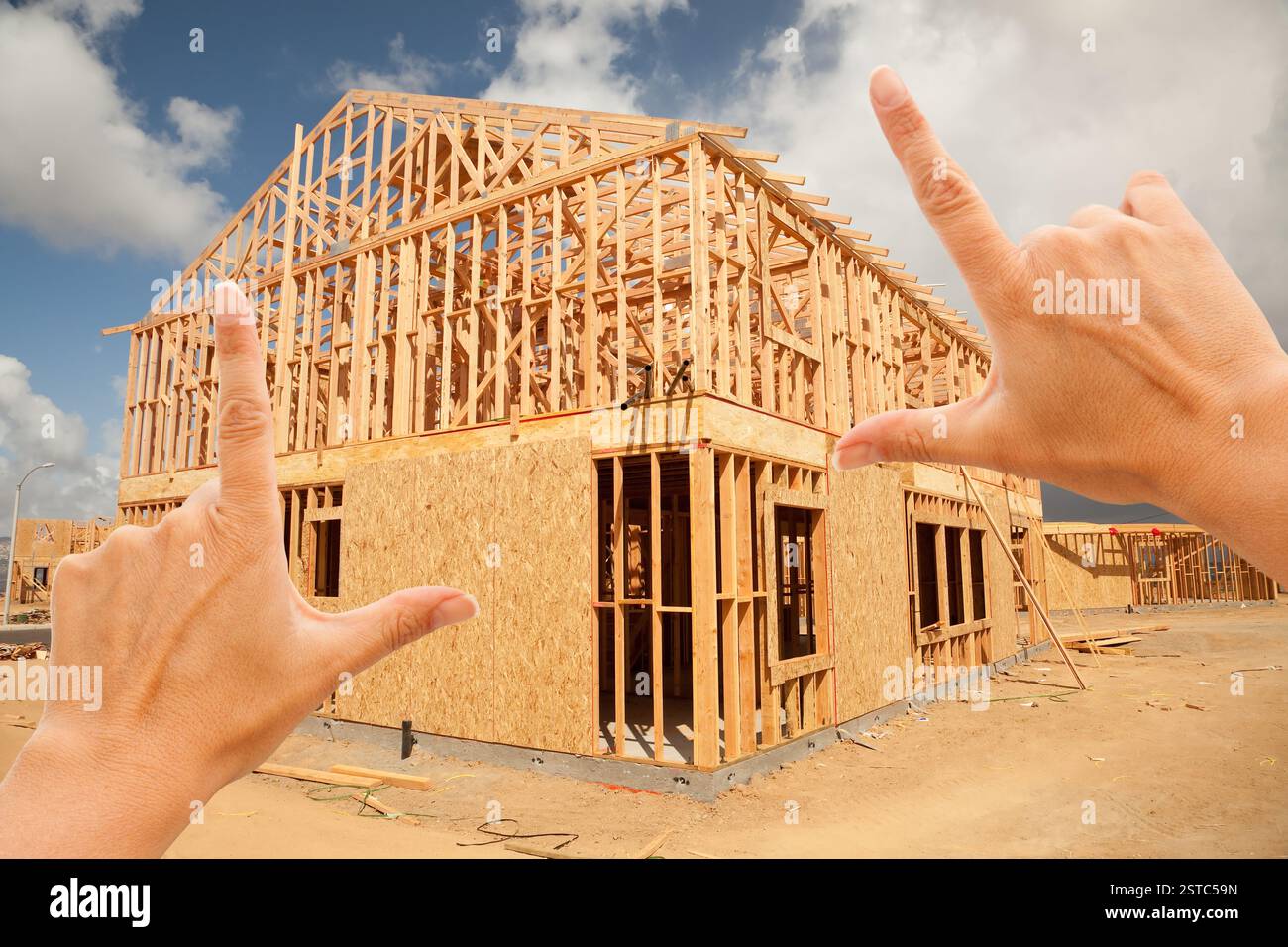 Female Hands Framing Home Frame on Construction Si Stock Photo