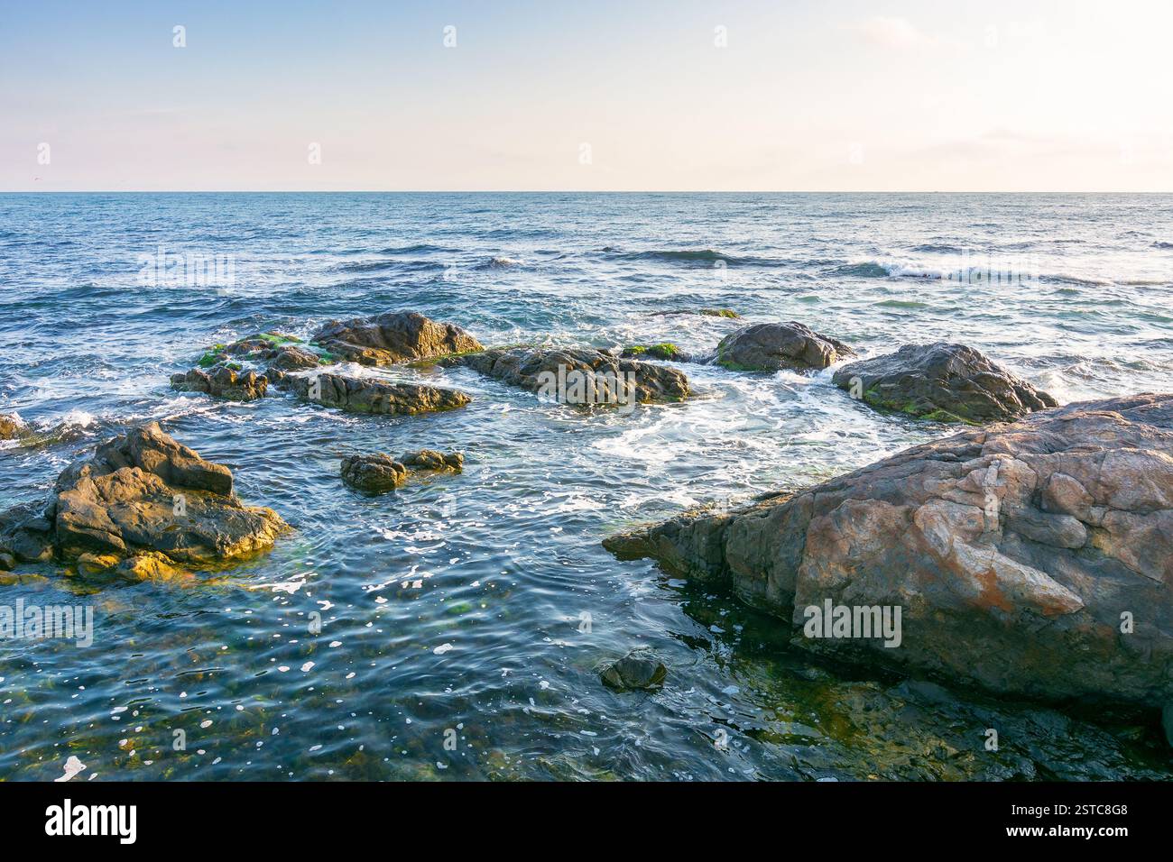 beautiful sunrise at the black sea. beautiful view. rocky coast and clouds on the blue sky in morning light. summer vacations and weather change conce Stock Photo
