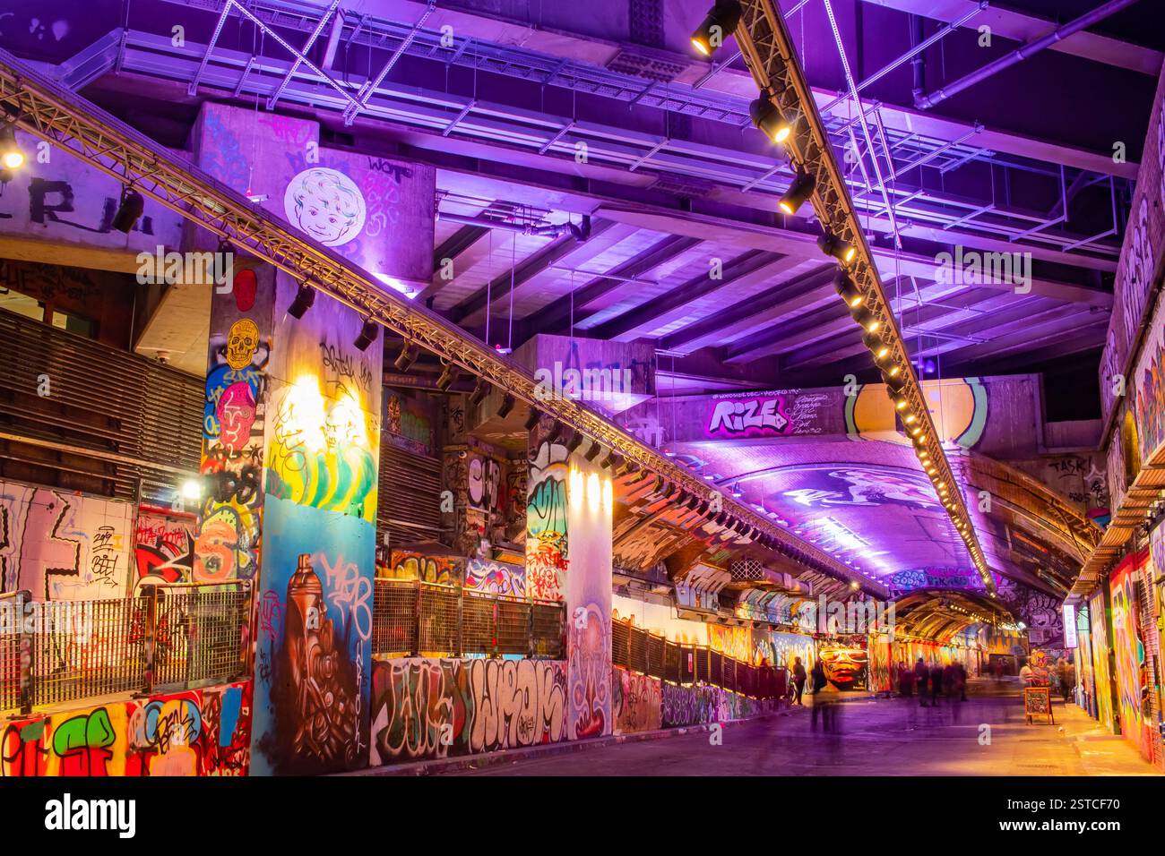 Purple lights and colorful street art murals at a London Graffiti Tunnel Stock Photo