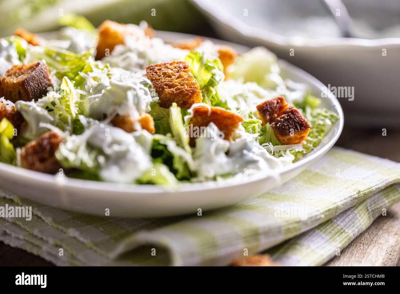 Healthy Caesar salad made with Romaine lettuce, croutons, tzatziki dressing and parmesan cheese.  Traditional Mediterranean Caesar salad originating f Stock Photo